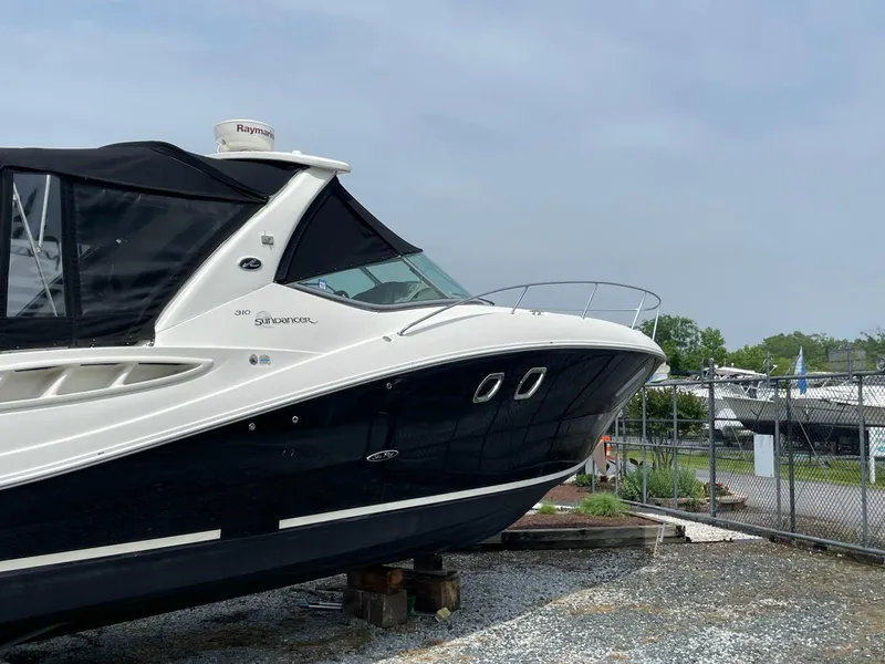 Slide: The Image of 2007 Sea Ray 310 Sundancer boat on dry dock, black and white exterior. - 4