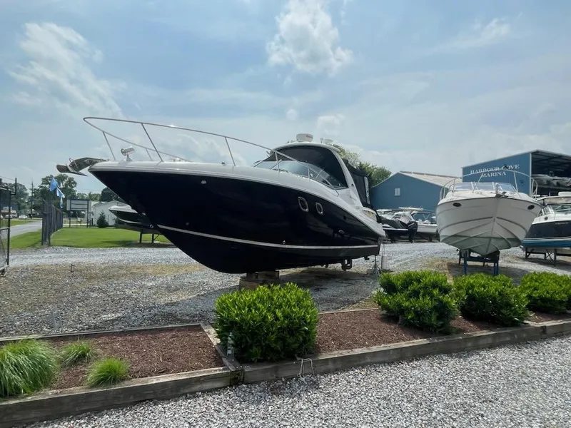 Slide: The Image of 2007 Sea Ray 310 Sundancer boat displayed outdoors on gravel lot. - 7