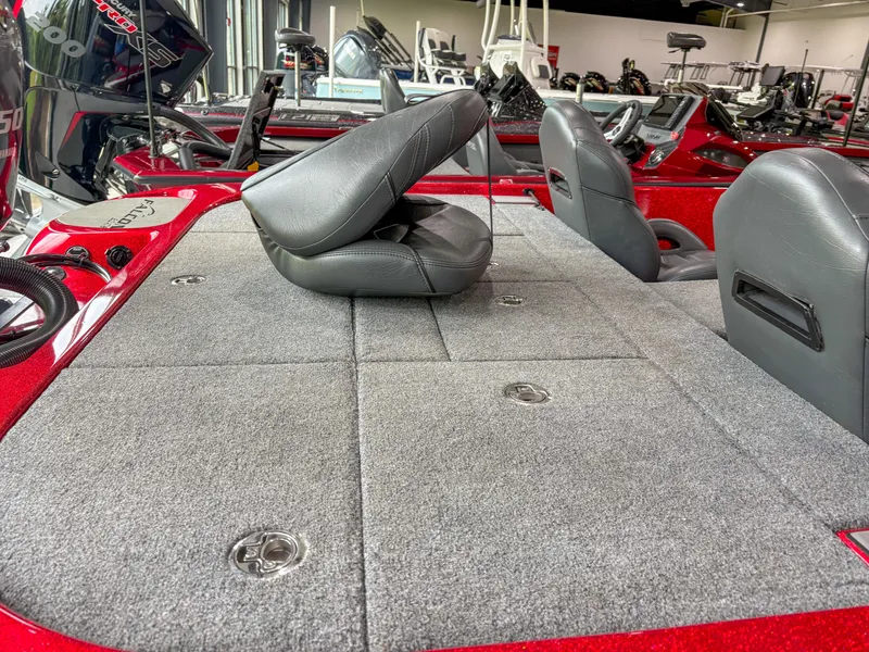 Slide: The Image of 2023 Falcon F185 boat interior with gray carpet and black seats in showroom. - 9