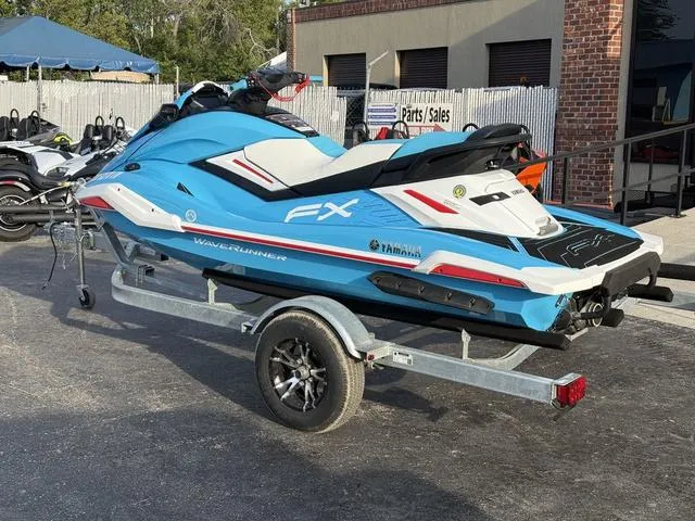 Slide: The Image of 2022 Yamaha Marine Waverunner FX on trailer, blue and white, parked outside dealership. - 5