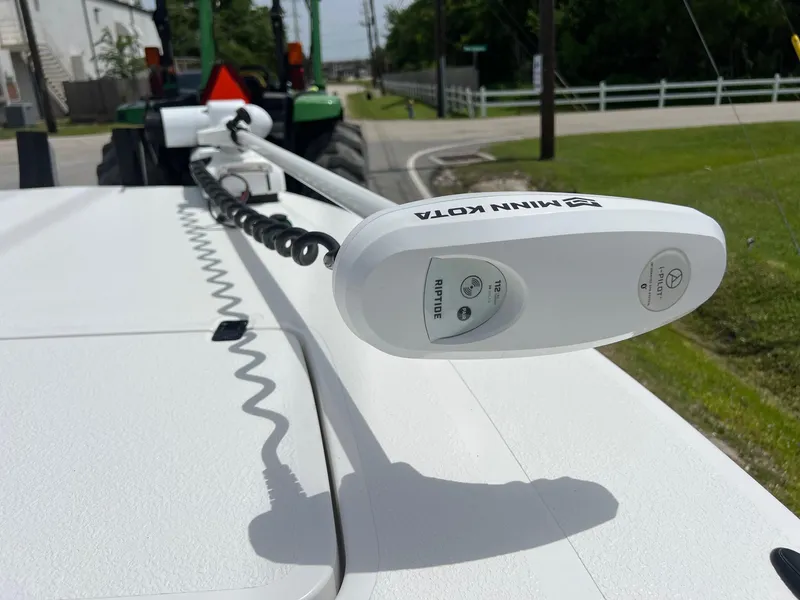 Slide: The Image of Minn Kota trolling motor on 2021 Majek REAPER boat, parked near a green tractor. - 18
