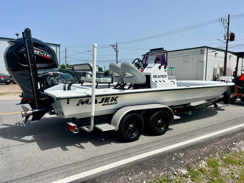 Slide: The Image of 2021 Majek REAPER boat on trailer, parked on street, featuring sleek design and powerful engine. - 4