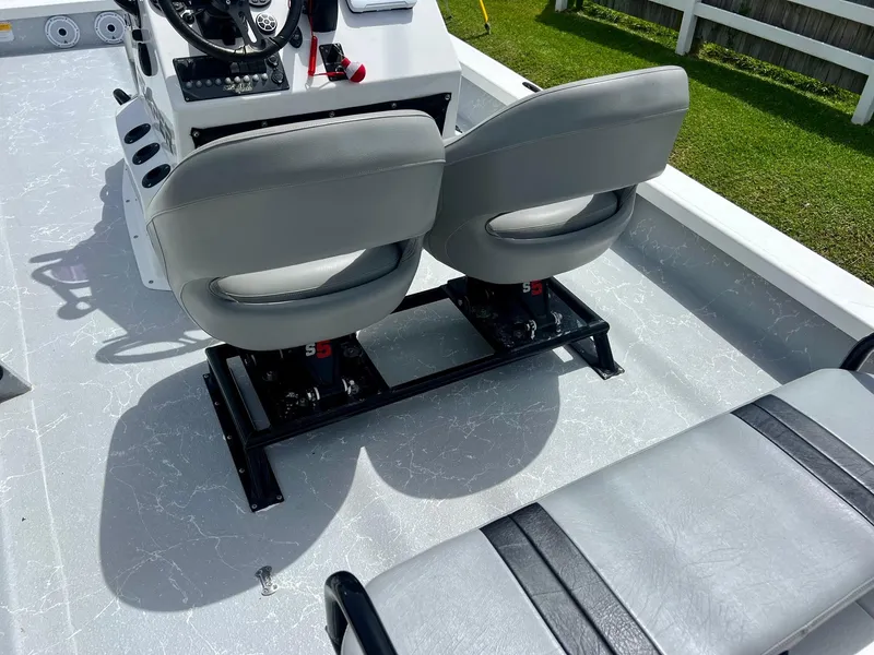 Slide: The Image of Two gray seats on a 2021 Majek REAPER boat deck, with steering console visible. - 9