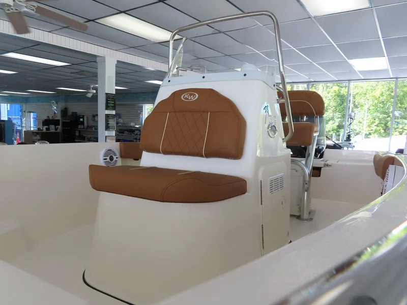 Slide: The Image of 2025 Key West 179 FS boat interior with brown seating, displayed indoors. - 14