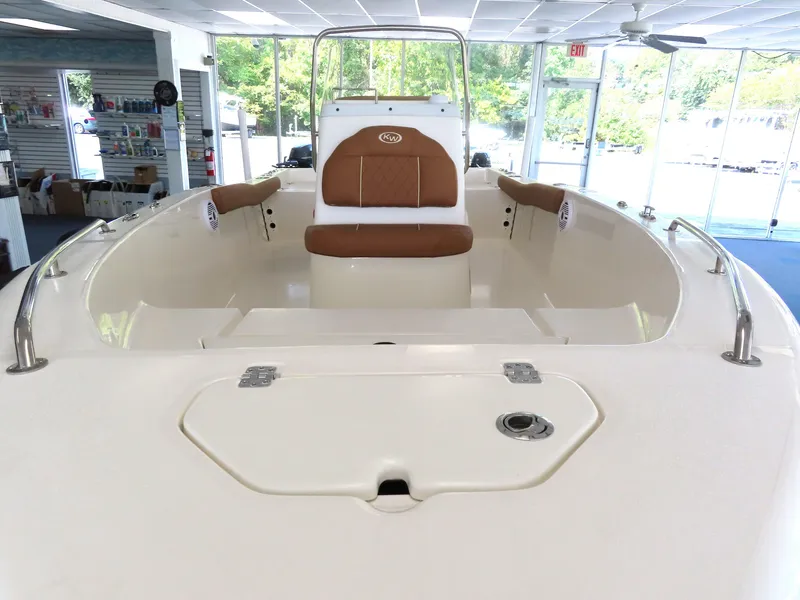Slide: The Image of 2025 Key West 179 FS boat interior with brown seating, displayed in a showroom. - 17