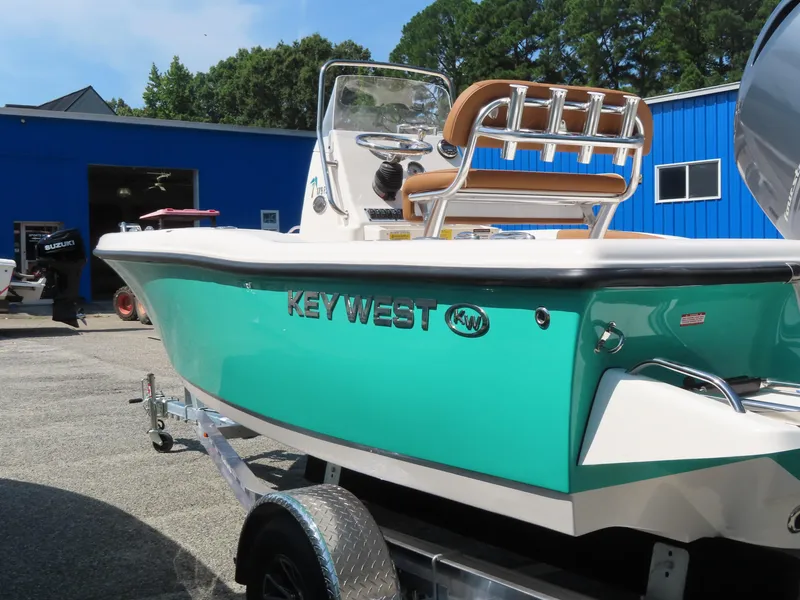 Slide: The Image of 2025 Key West 179 FS boat in vibrant teal on a trailer, parked outdoors. - 6