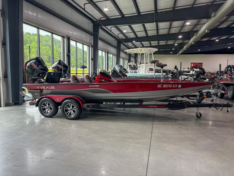 Slide: The Image of 2022 Vexus AVX 2080 boat in showroom, red and gray design, on trailer. - 1