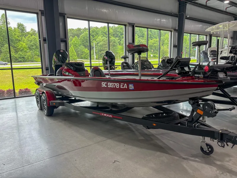 Slide: The Image of 2022 Vexus AVX 2080 boat in showroom, red and white, on trailer. - 2