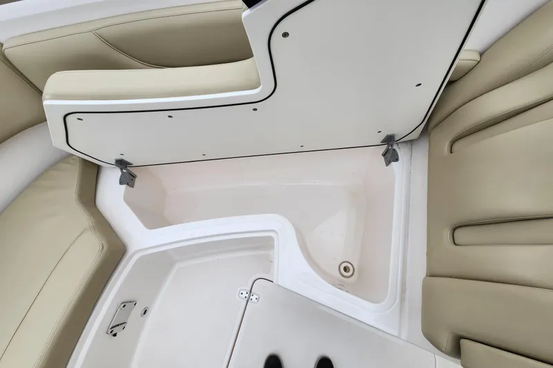 Slide: The Image of 2017 Pursuit DC 325 Dual Console interior with beige seating and storage compartment. - 15