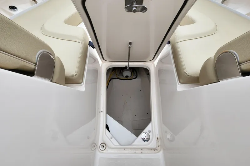 Slide: The Image of 2017 Pursuit DC 325 Dual Console boat storage compartment with open hatch and seating. - 16