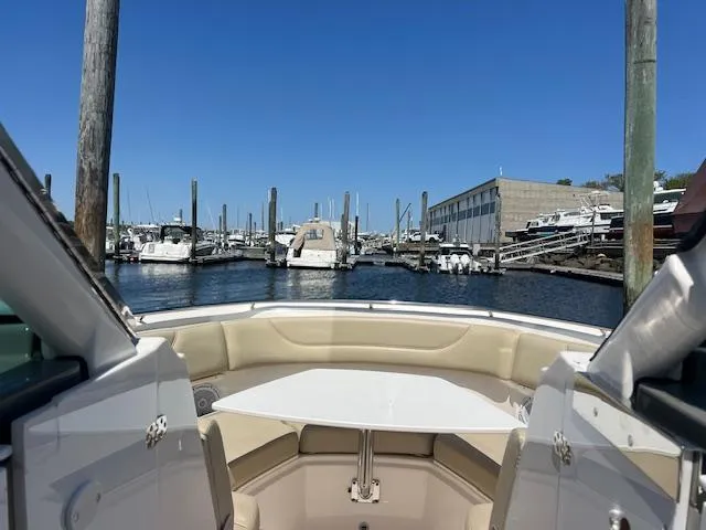 Slide: The Image of 2017 Pursuit DC 325 Dual Console boat docked in a marina under clear blue skies. - 18