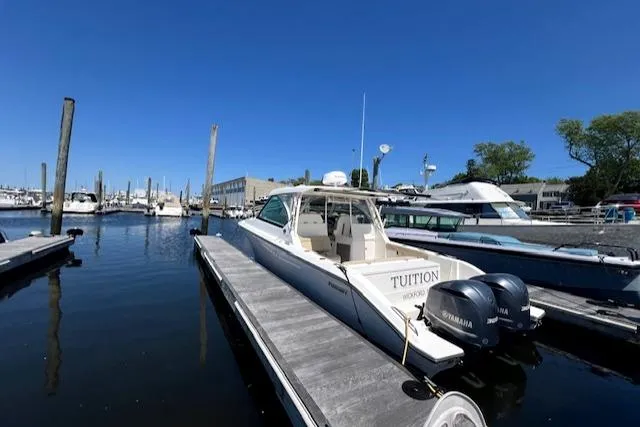 Slide: The Image of 2017 Pursuit DC 325 Dual Console boat docked at marina with Yamaha engines. - 2