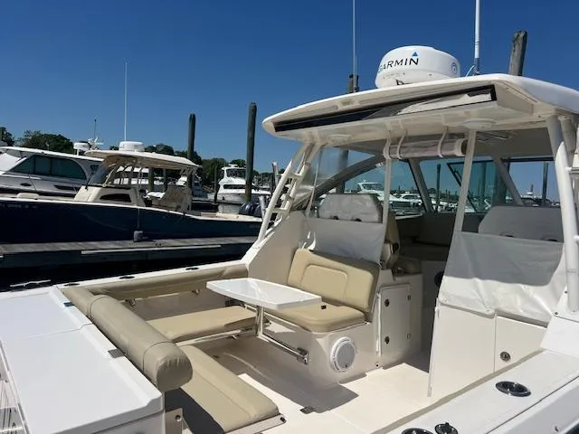 Slide: The Image of 2017 Pursuit DC 325 Dual Console boat docked at marina, featuring spacious seating and modern design. - 21