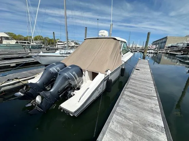 Slide: The Image of 2017 Pursuit DC 325 Dual Console boat docked with twin engines, covered canopy. - 3