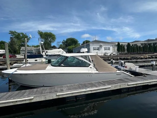 Slide: The Image of 2017 Pursuit DC 325 Dual Console boat docked at marina under clear sky. - 4