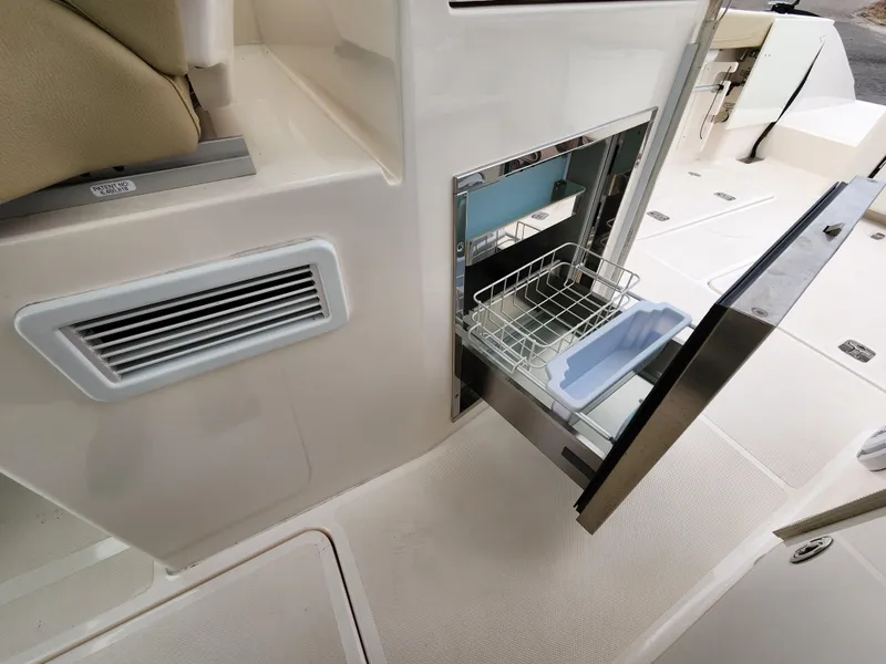 Slide: The Image of 2017 Pursuit DC 325 Dual Console boat with open storage compartment. - 6