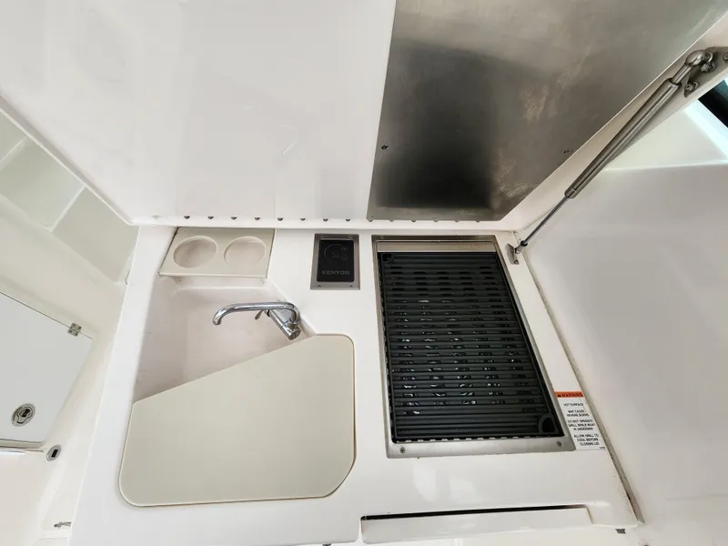 Slide: The Image of 2017 Pursuit DC 325 Dual Console boat kitchen with sink and grill. - 8