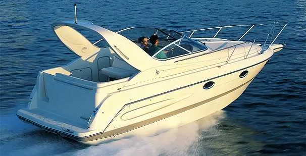 The Image of 2000 Maxum 2800 SCR boat on gravel lot under clear blue sky. - 0