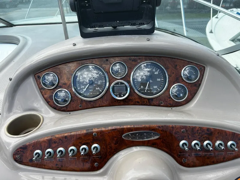 Slide: The Image of 2000 Maxum 2800 SCR boat with white seating and sleek design in a marina setting. - 10