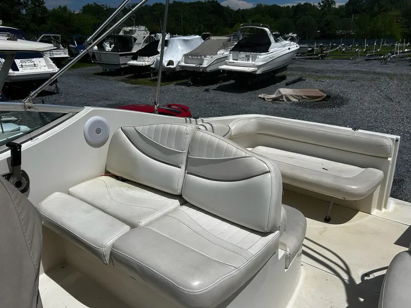 Slide: The Image of 2000 Maxum 2800 SCR boat interior with white seating and outdoor storage area. - 12
