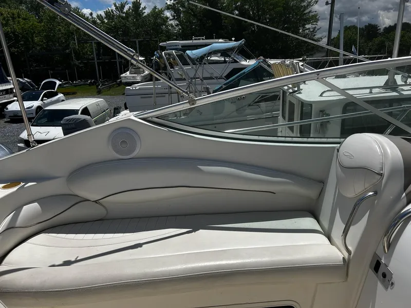 Slide: The Image of 2000 Maxum 2800 SCR boat with white seating and sleek design in a marina setting. - 13