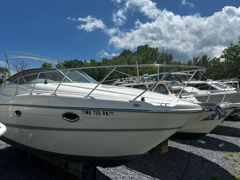 Slide: The Image of 2000 Maxum 2800 SCR boat on display under a partly cloudy sky. - 3