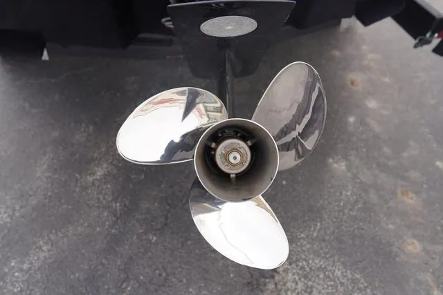 Slide: The Image of 2024 Sea Ray SPX 210 boat propeller, shiny metal blades on a concrete surface. - 10