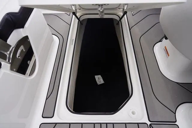 Slide: The Image of 2024 Sea Ray SPX 210 boat storage compartment with open hatch and sleek interior design. - 14