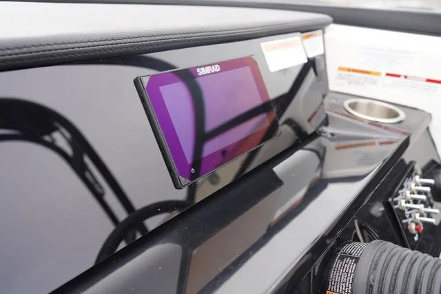 Slide: The Image of 2024 Sea Ray SPX 210 dashboard with Simrad display and cup holder. - 26