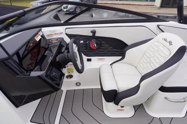 Slide: The Image of 2024 Sea Ray SPX 210 boat interior with steering wheel and captain's seat. - 28