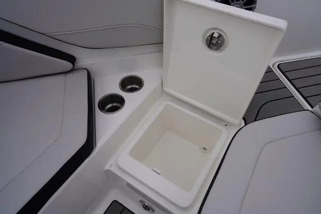 Slide: The Image of 2024 Sea Ray SPX 210 boat interior with open storage compartment and cup holders. - 42