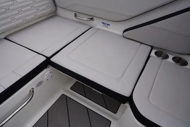Slide: The Image of 2024 Sea Ray SPX 210 boat interior with cushioned seating and cup holders. - 44