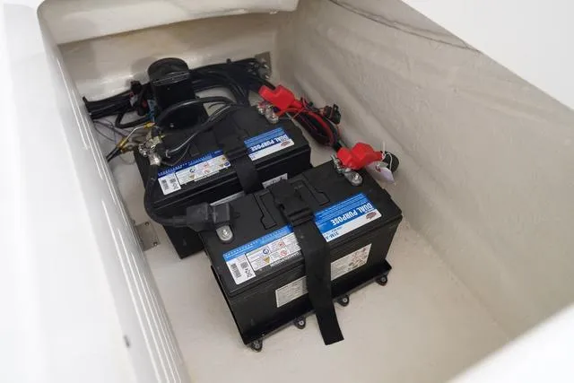Slide: The Image of 2024 Sea Ray SPX 210 boat battery compartment with dual batteries and wiring. - 49