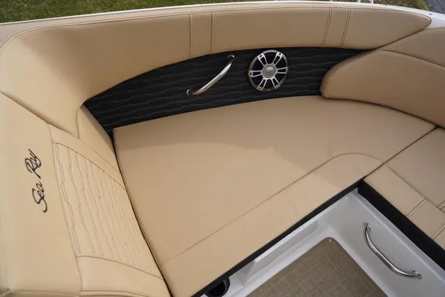 Slide: The Image of 2024 Sea Ray SPX 230 boat interior with beige seating and speaker detail. - 11