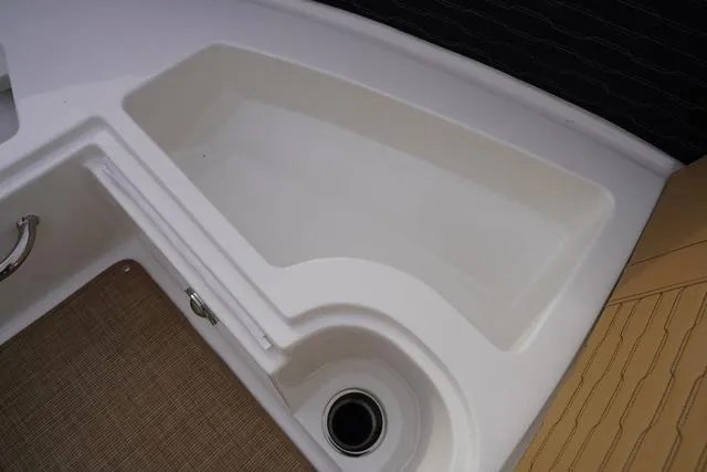 Slide: The Image of 2024 Sea Ray SPX 230 boat interior detail with storage compartment and drain. - 16