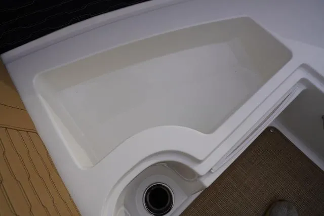 Slide: The Image of 2024 Sea Ray SPX 230 boat interior detail with storage compartment and cup holder. - 18