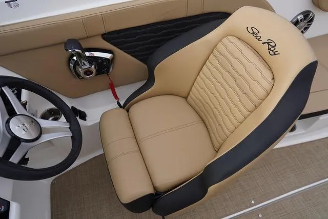 Slide: The Image of 2024 Sea Ray SPX 230 boat interior with tan and black captain's seat and steering wheel. - 20