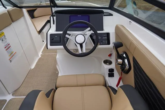 Slide: The Image of 2024 Sea Ray SPX 230 boat interior with modern steering and beige seating. - 21