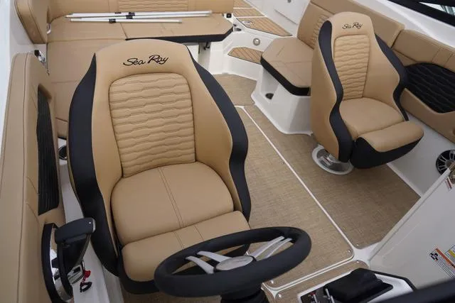 Slide: The Image of 2024 Sea Ray SPX 230 boat interior with tan and black seating, featuring a steering wheel. - 29