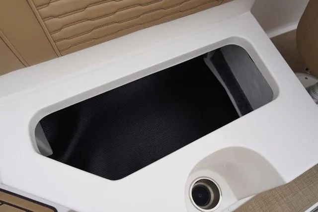 Slide: The Image of 2024 Sea Ray SPX 230 storage compartment with cup holder, featuring beige upholstery. - 33