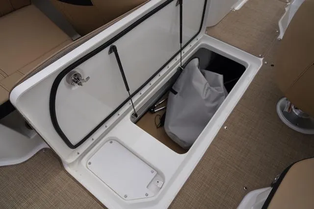 Slide: The Image of 2024 Sea Ray SPX 230 boat storage compartment with open hatch and stored items. - 35