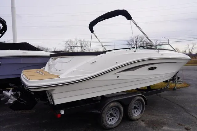 Slide: The Image of 2024 Sea Ray SPX 230 boat on trailer, white exterior, black canopy, parked outdoors. - 4