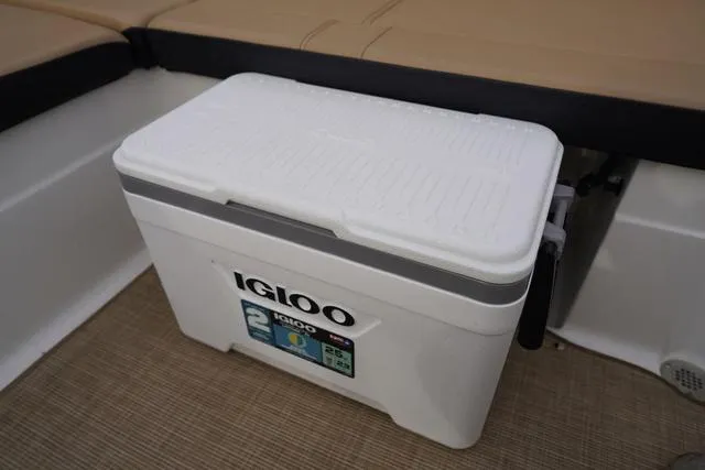 Slide: The Image of Igloo cooler on 2024 Sea Ray SPX 230 boat, beige seating, and carpeted floor. - 42