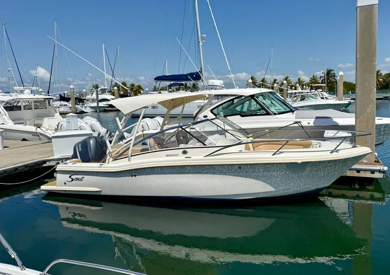 The Image of 2016 Scout 245 Dorado boat docked in a marina under clear blue skies. - 0