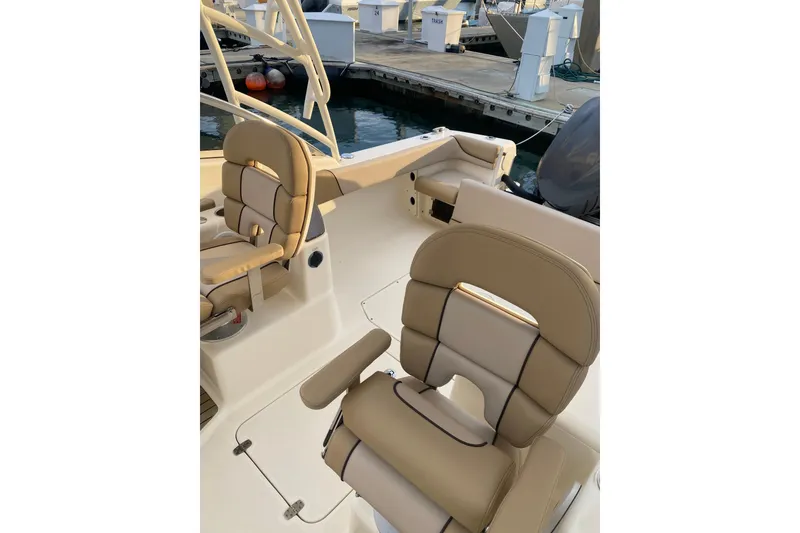 Slide: The Image of 2016 Scout 245 Dorado boat interior with beige seating at marina. - 2