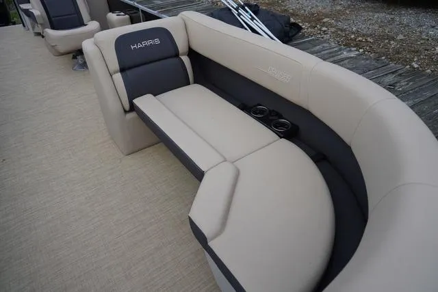 Slide: The Image of 2024 Harris Cruiser 230 CWDH boat seating with beige upholstery and cup holders. - 13