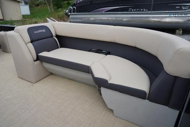 Slide: The Image of 2024 Harris Cruiser 230 CWDH boat seating, featuring beige and gray upholstery with cup holders. - 16