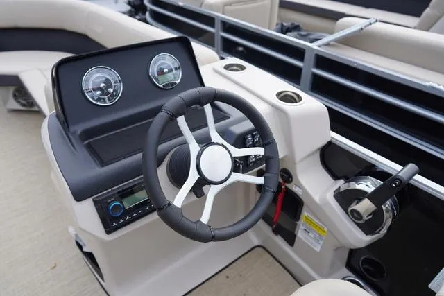 Slide: The Image of 2024 Harris Cruiser 230 CWDH boat dashboard with steering wheel and controls. - 21