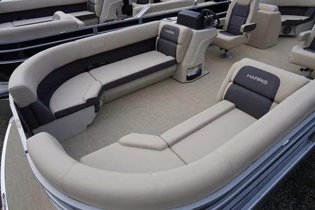 Slide: The Image of 2024 Harris Cruiser 230 CWDH pontoon boat interior with beige seating and steering console. - 3