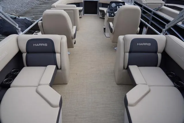Slide: The Image of 2024 Harris Cruiser 230 CWDH pontoon boat interior with beige seating and steering console. - 30